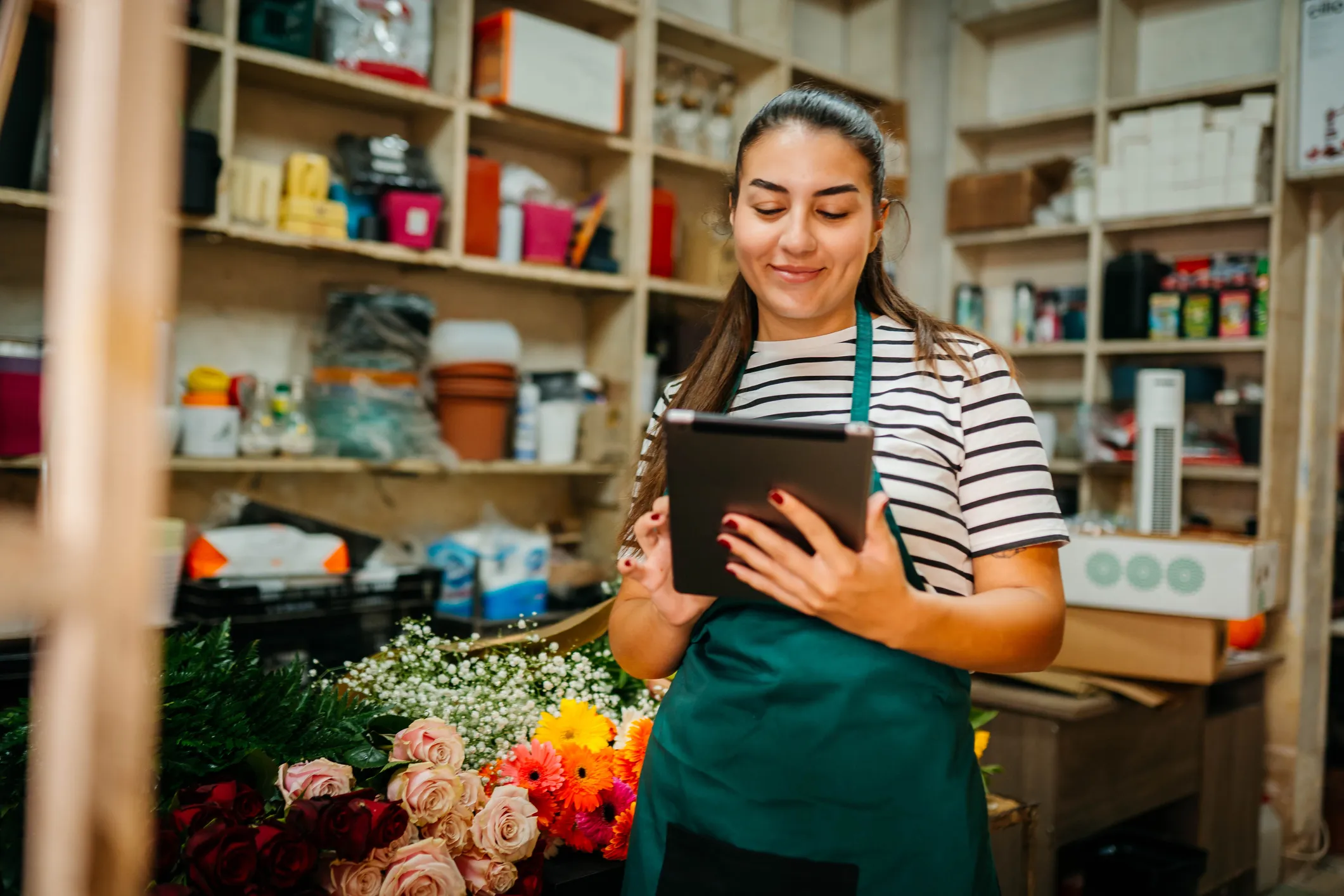 Dependienta de una floristería usando una tableta en su tienda
